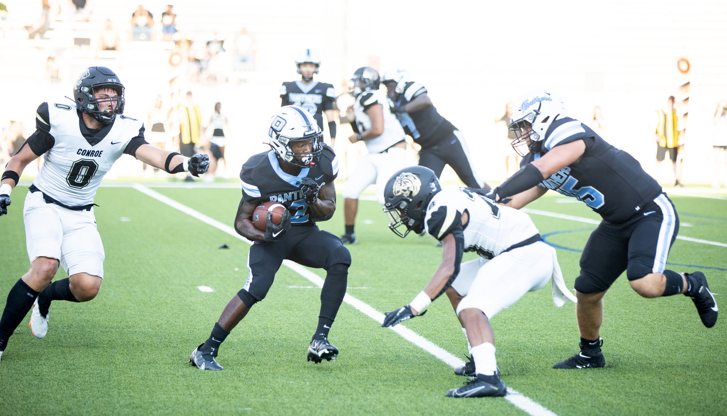 Paetow’s Derrick Johnson evades a defender during Friday’s game against Conroe at Legacy Stadium.